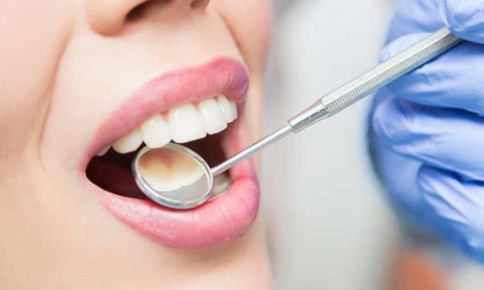Dentist examining a patient's teeth with a dental mirror